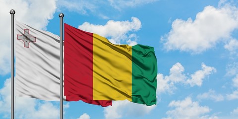 Malta and Guinea flag waving in the wind against white cloudy blue sky together. Diplomacy concept, international relations.