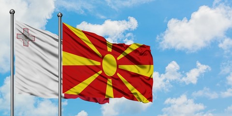Malta and Macedonia flag waving in the wind against white cloudy blue sky together. Diplomacy concept, international relations.
