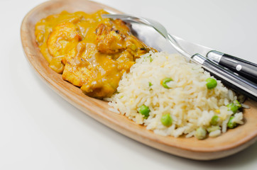 Roasted chicken breast pieces in a mildly spiced coconut curry sauce with fried rice with peas and egg