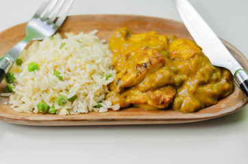 Roasted chicken breast pieces in a mildly spiced coconut curry sauce with fried rice with peas and egg