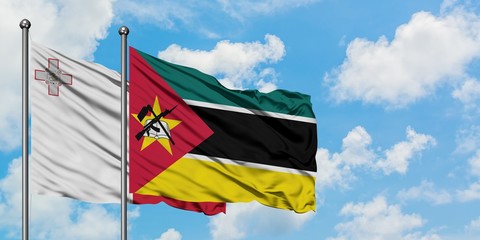 Malta and Mozambique flag waving in the wind against white cloudy blue sky together. Diplomacy concept, international relations.