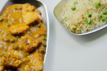 Roasted chicken breast pieces in a mildly spiced coconut curry sauce with fried rice with peas and egg