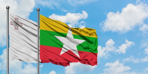 Malta and Myanmar flag waving in the wind against white cloudy blue sky together. Diplomacy concept, international relations.