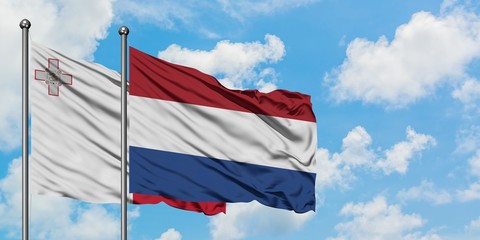 Malta and Netherlands flag waving in the wind against white cloudy blue sky together. Diplomacy concept, international relations.