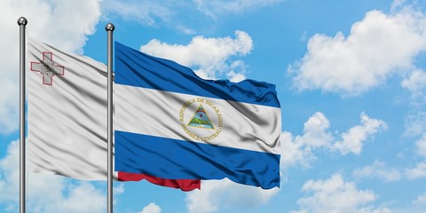 Malta and Nicaragua flag waving in the wind against white cloudy blue sky together. Diplomacy concept, international relations.