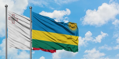 Malta and Rwanda flag waving in the wind against white cloudy blue sky together. Diplomacy concept, international relations.