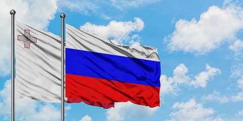 Malta and Russia flag waving in the wind against white cloudy blue sky together. Diplomacy concept, international relations.