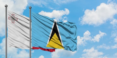 Malta and Saint Lucia flag waving in the wind against white cloudy blue sky together. Diplomacy concept, international relations.