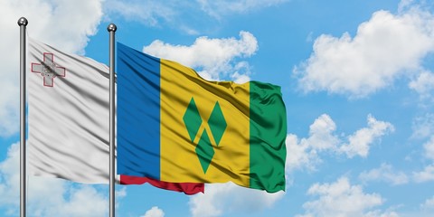Malta and Saint Vincent And The Grenadines flag waving in the wind against white cloudy blue sky...