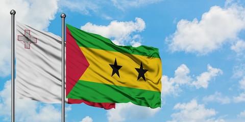 Malta and Sao Tome And Principe flag waving in the wind against white cloudy blue sky together. Diplomacy concept, international relations.