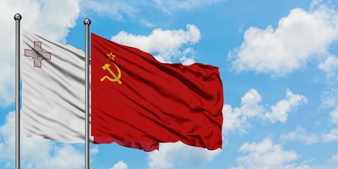 Malta and Soviet Union flag waving in the wind against white cloudy blue sky together. Diplomacy concept, international relations.
