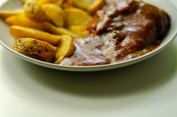 Cooked chicken breast fillet in a barbecue sauce, topped with smoked bacon and Red Leicester cheese and served with potato wedges
