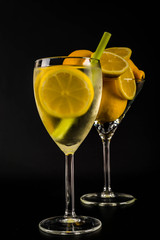 Lemon slices in a transparent drink in a glass on a black background