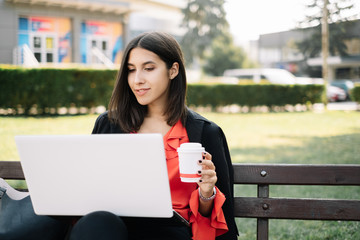 Woman sitting on a bench with laptop