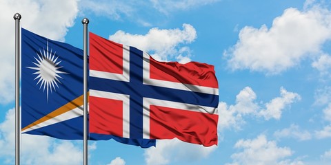 Marshall Islands and Bouvet Islands flag waving in the wind against white cloudy blue sky together. Diplomacy concept, international relations.