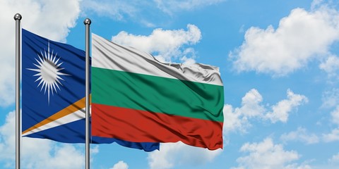Marshall Islands and Bulgaria flag waving in the wind against white cloudy blue sky together. Diplomacy concept, international relations.