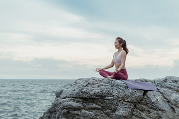 Side view of woman doing exercise yoga. sitting in Sukhasana exercise, Easy Seat pose pose. Amazing...