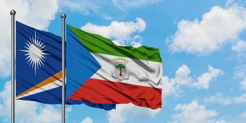 Marshall Islands and Equatorial Guinea flag waving in the wind against white cloudy blue sky together. Diplomacy concept, international relations.