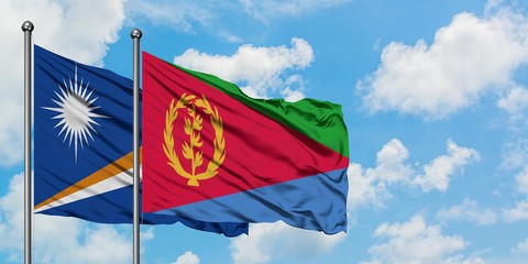 Marshall Islands and Eritrea flag waving in the wind against white cloudy blue sky together. Diplomacy concept, international relations.