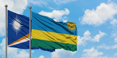 Marshall Islands and Rwanda flag waving in the wind against white cloudy blue sky together. Diplomacy concept, international relations.