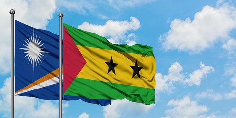 Marshall Islands and Sao Tome And Principe flag waving in the wind against white cloudy blue sky together. Diplomacy concept, international relations.