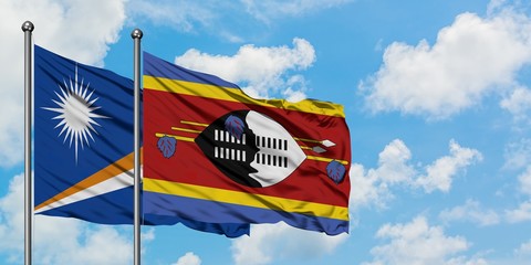 Marshall Islands and Swaziland flag waving in the wind against white cloudy blue sky together. Diplomacy concept, international relations.