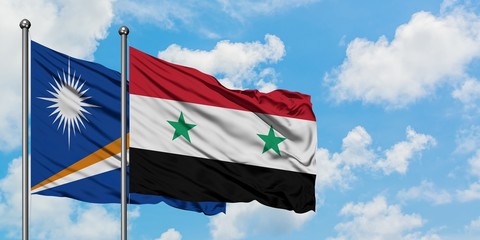 Marshall Islands and Syria flag waving in the wind against white cloudy blue sky together. Diplomacy concept, international relations.
