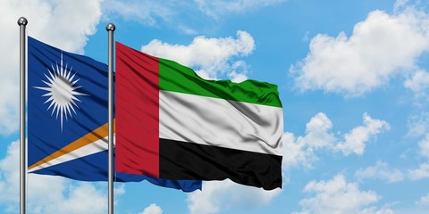 Fototapeta na wymiar Marshall Islands and United Arab Emirates flag waving in the wind against white cloudy blue sky together. Diplomacy concept, international relations.