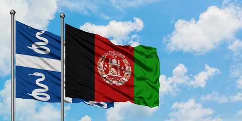 Martinique and Afghanistan flag waving in the wind against white cloudy blue sky together. Diplomacy concept, international relations.