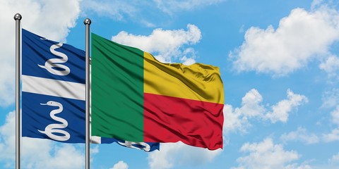 Martinique and Benin flag waving in the wind against white cloudy blue sky together. Diplomacy concept, international relations.