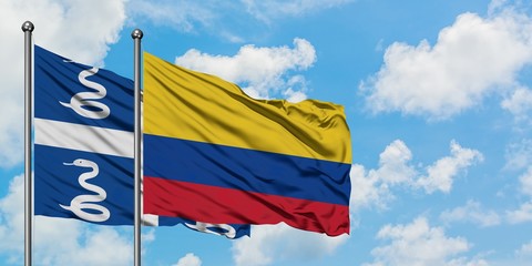 Martinique and Colombia flag waving in the wind against white cloudy blue sky together. Diplomacy concept, international relations.