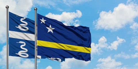 Martinique and Curacao flag waving in the wind against white cloudy blue sky together. Diplomacy concept, international relations.