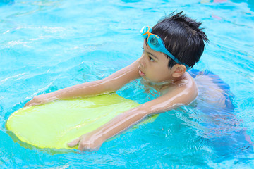 Asian boy happy swimming and playing in water, happiness and summertime. Activities on the pool.