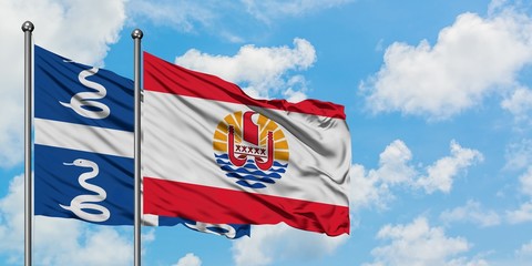 Martinique and French Polynesia flag waving in the wind against white cloudy blue sky together. Diplomacy concept, international relations.