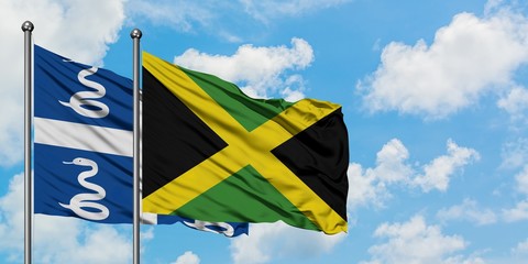 Martinique and Jamaica flag waving in the wind against white cloudy blue sky together. Diplomacy concept, international relations.