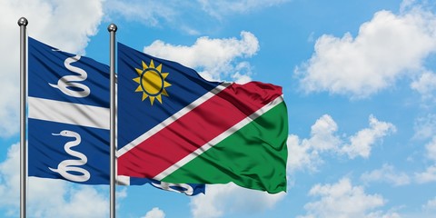 Martinique and Namibia flag waving in the wind against white cloudy blue sky together. Diplomacy concept, international relations.