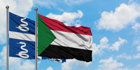 Martinique and Sudan flag waving in the wind against white cloudy blue sky together. Diplomacy concept, international relations.