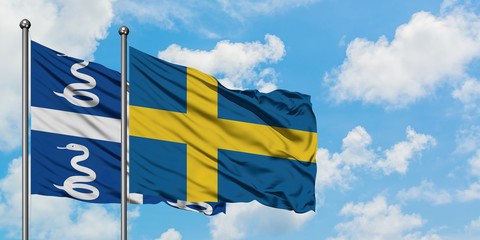 Martinique and Sweden flag waving in the wind against white cloudy blue sky together. Diplomacy concept, international relations.