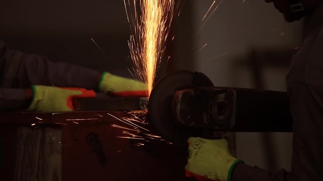 the concept for safety first, Man works circular saw, Flies of spark from hot metal, The man's hard work. Man Chlef and smooth surface, Man worked over the steel, close-up of a hand