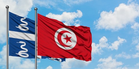 Martinique and Tunisia flag waving in the wind against white cloudy blue sky together. Diplomacy concept, international relations.