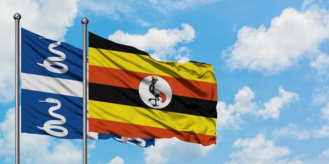 Martinique and Uganda flag waving in the wind against white cloudy blue sky together. Diplomacy concept, international relations.
