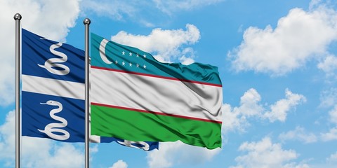 Martinique and Uzbekistan flag waving in the wind against white cloudy blue sky together. Diplomacy concept, international relations.