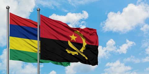 Mauritius and Angola flag waving in the wind against white cloudy blue sky together. Diplomacy concept, international relations.