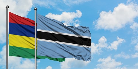 Mauritius and Botswana flag waving in the wind against white cloudy blue sky together. Diplomacy concept, international relations.