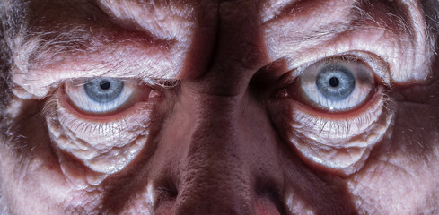 Close-up of the face of an elderly man. His wrinkled face forms light and shadow.