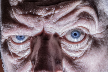 Close-up of the face of an elderly man. His wrinkled face forms light and shadow.