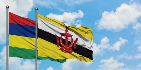 Mauritius and Brunei flag waving in the wind against white cloudy blue sky together. Diplomacy concept, international relations.