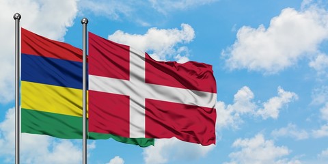 Mauritius and Denmark flag waving in the wind against white cloudy blue sky together. Diplomacy concept, international relations.