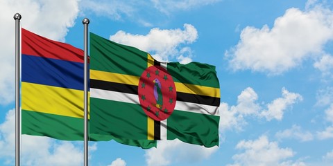 Mauritius and Dominica flag waving in the wind against white cloudy blue sky together. Diplomacy concept, international relations.