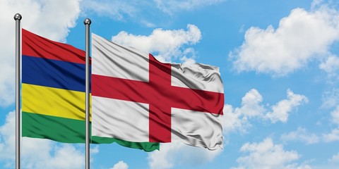Mauritius and England flag waving in the wind against white cloudy blue sky together. Diplomacy concept, international relations.